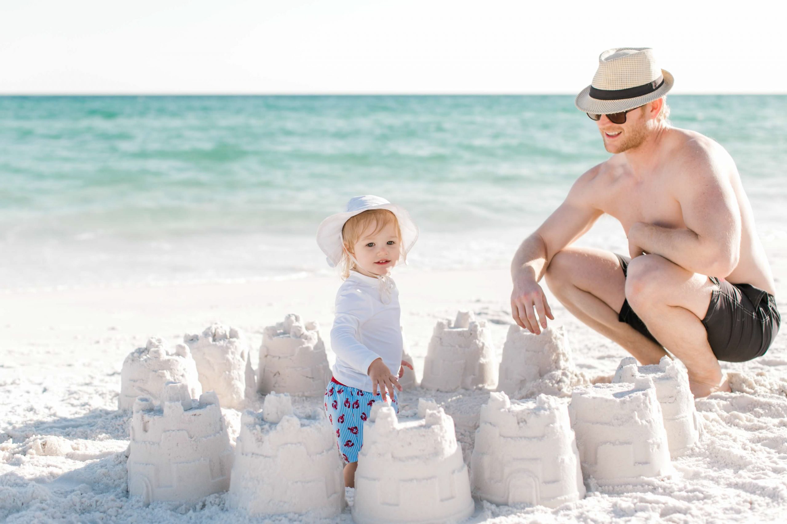 toddler with sandcastles on beach on easter vacation