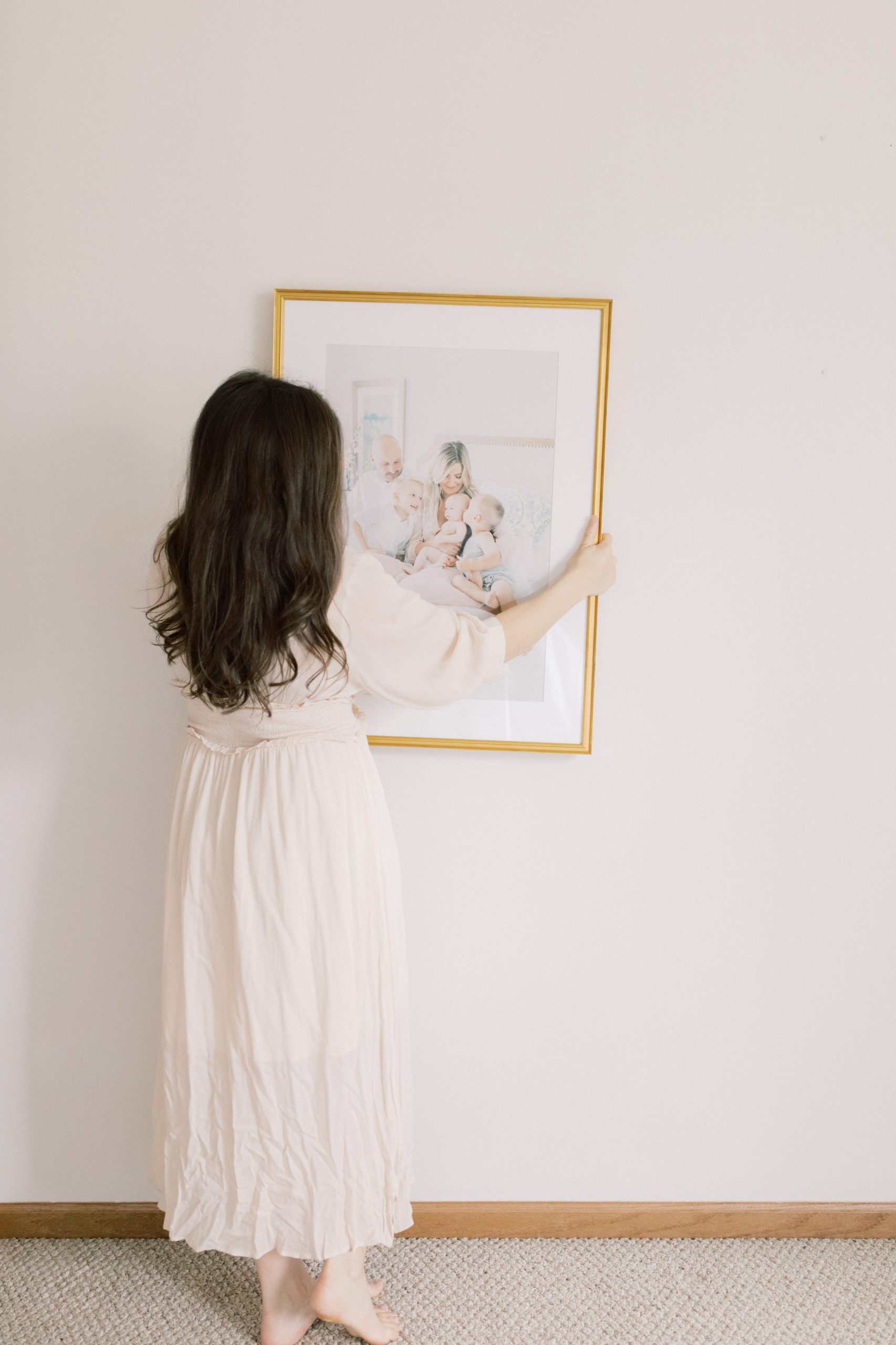 milwaukee family photographer talia laird holds a framed portrait from a family photo session