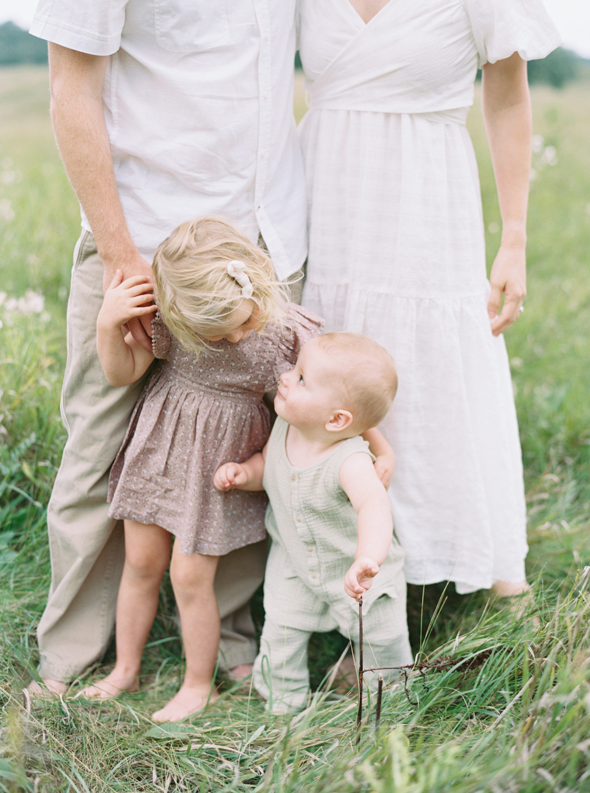 siblings during their family session in Milwaukee in a green field