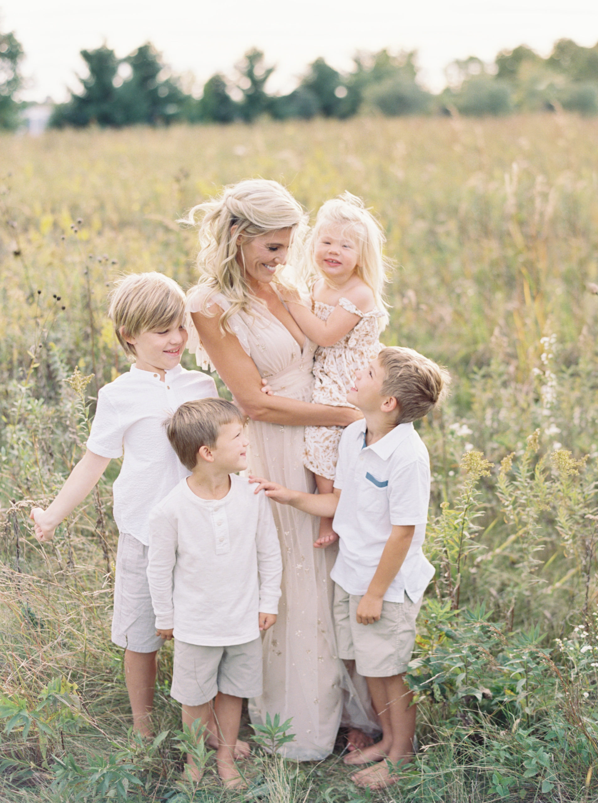 family cuddles in a Middleton grassy field