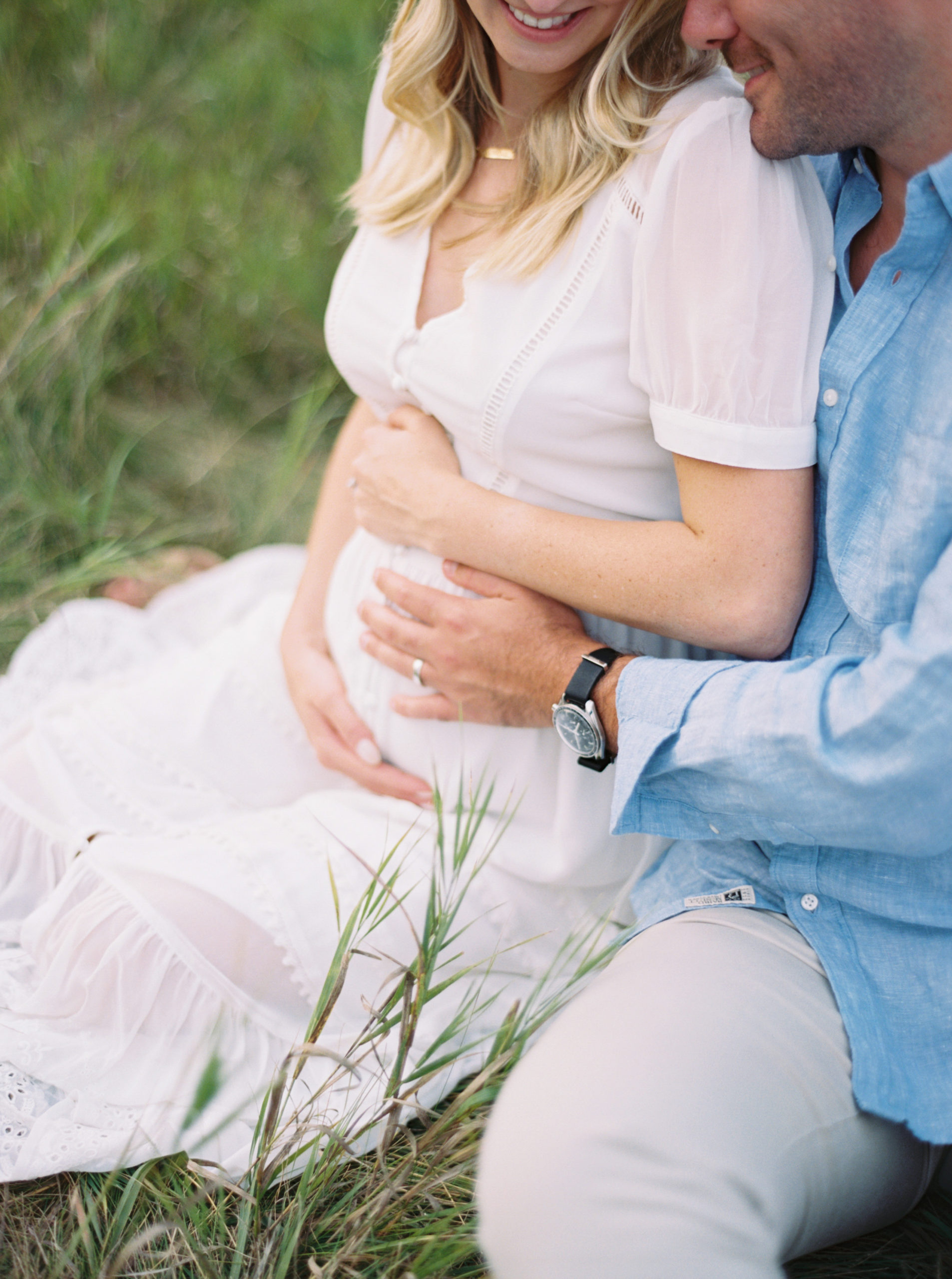 photo of pregnant mother snuggling husband in field taken by Milwaukee Maternity Photographer, Talia Laird Photography