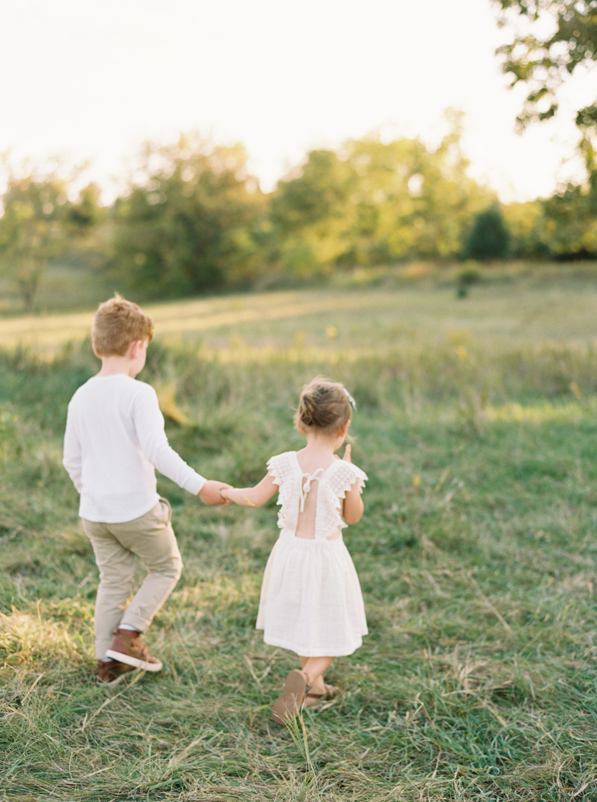 Brother and Sister in a grassy green field setting in Shorewood in the summer