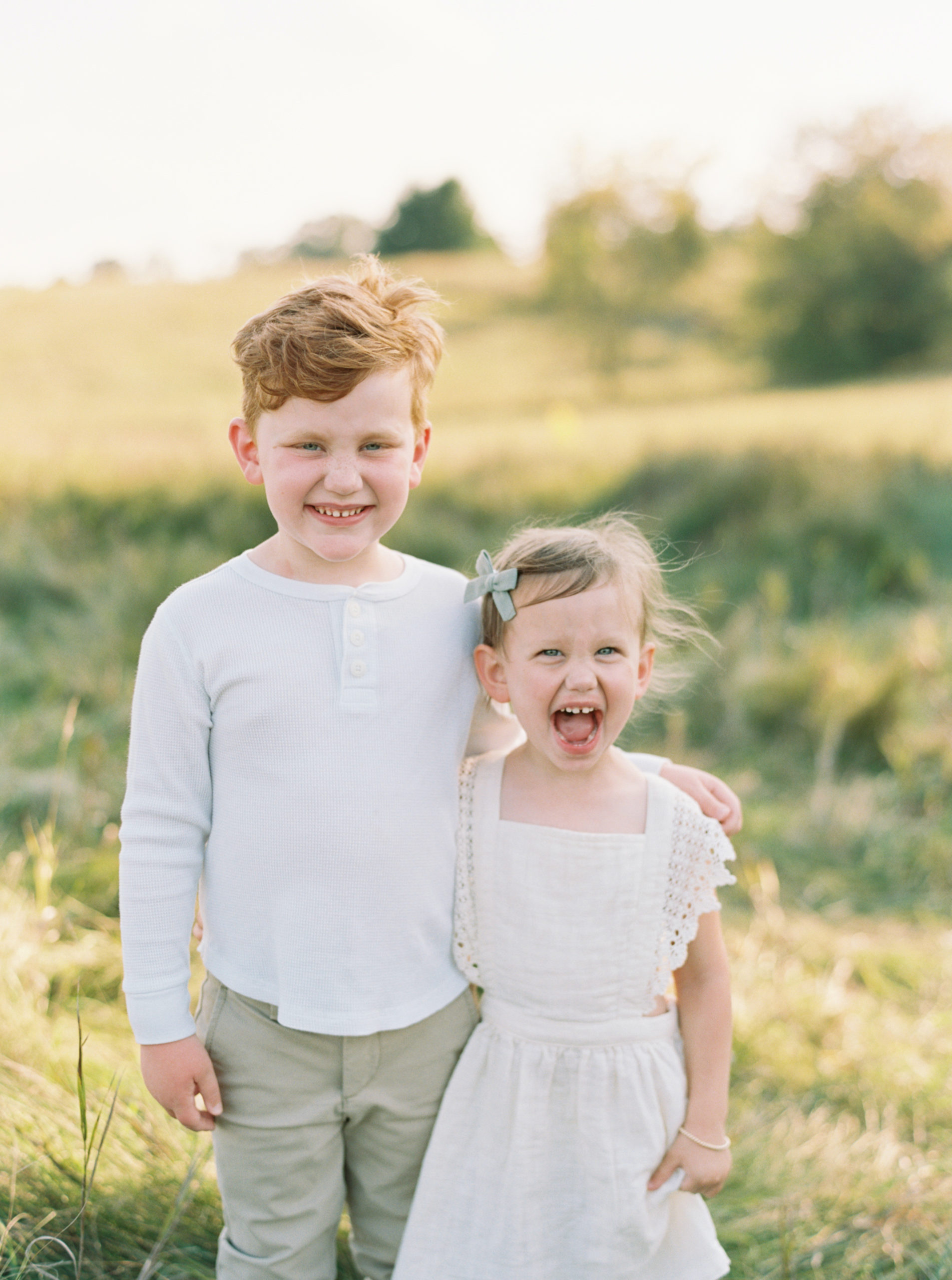 Brother and Sister in a grassy green field setting in Shorewood in the summer