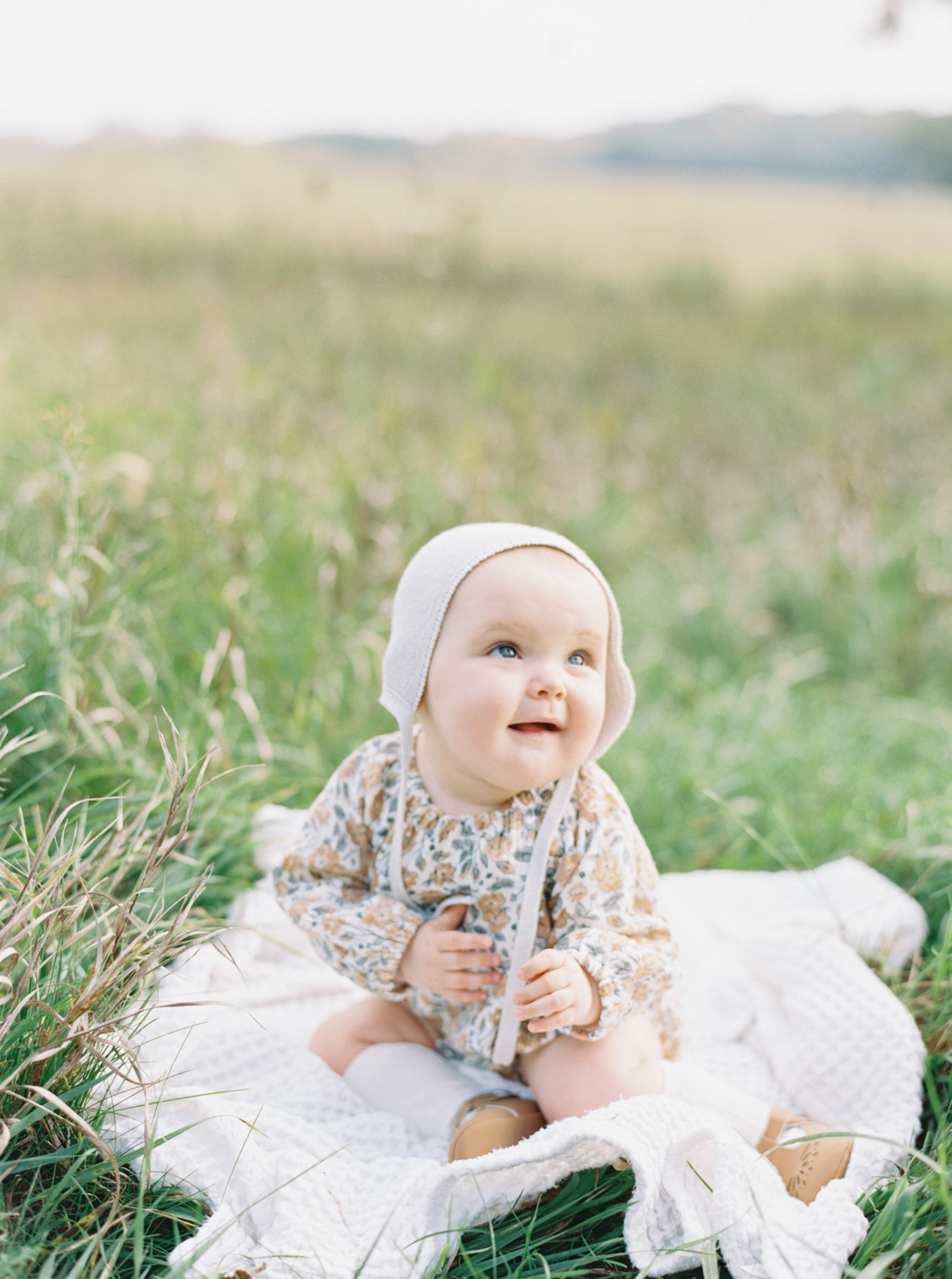 Baby playing in a grassy Hartland field on a beautiful Fall afternoon