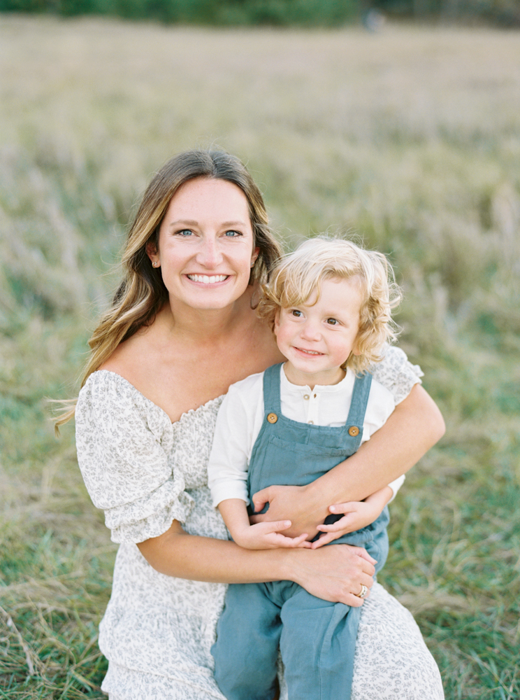 Mother cuddles son in beautiful, green, grassy Milwaukee field