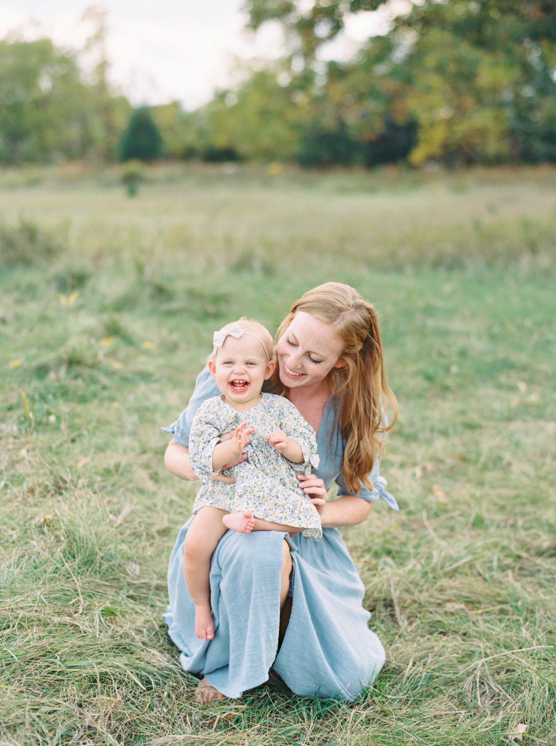 Mother holding baby in Waunakee beautiful green field