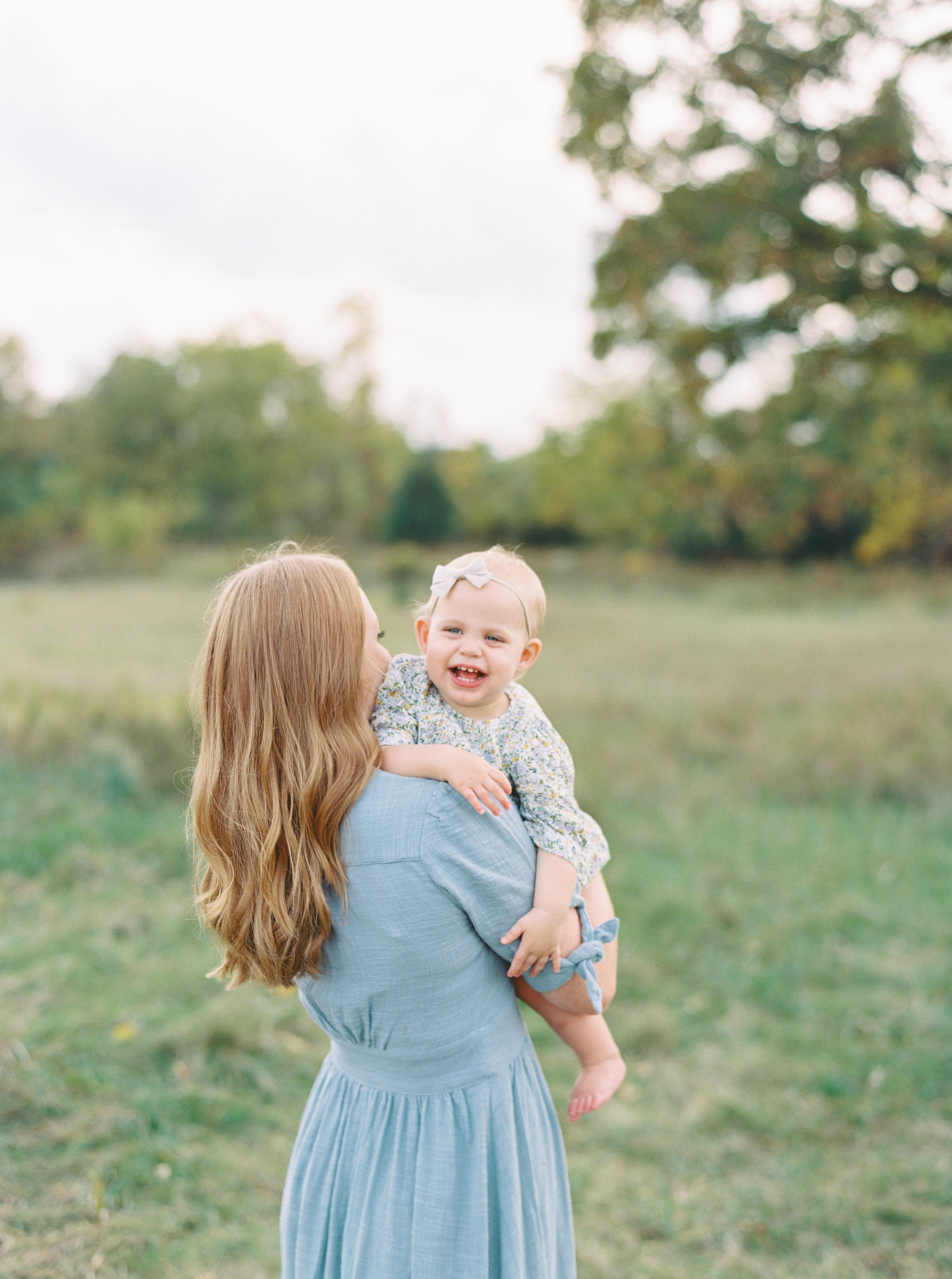 Mother holding baby in Waunakee beautiful green field