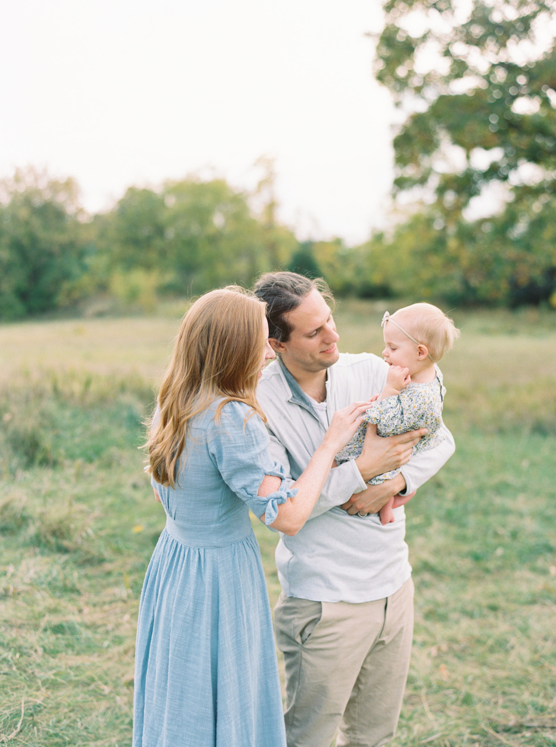 Family holding their baby in Waunakee beautiful green field