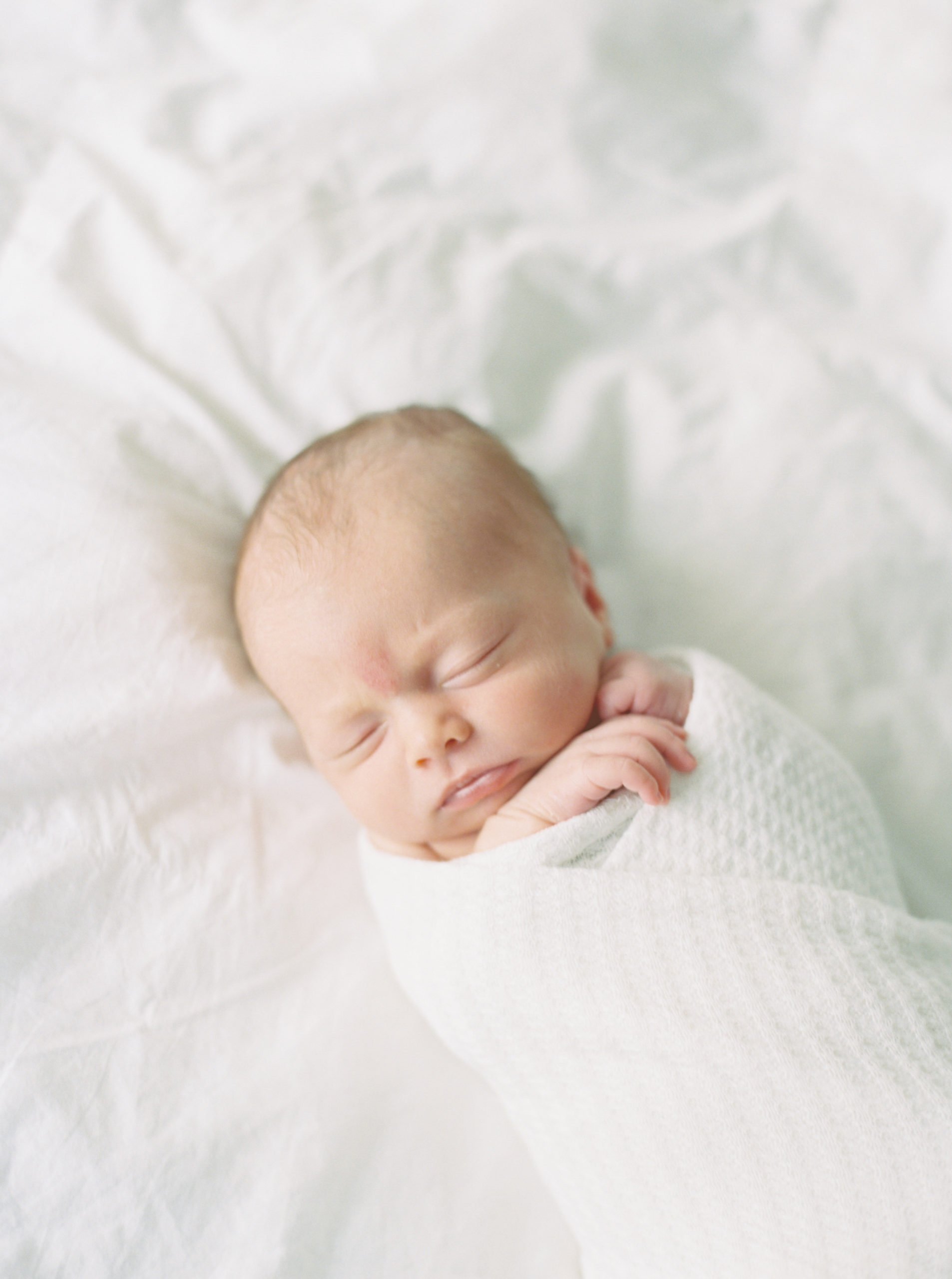 sleeping newborn in white bright bedroom taken by photographer in milwaukee Talia laird photography