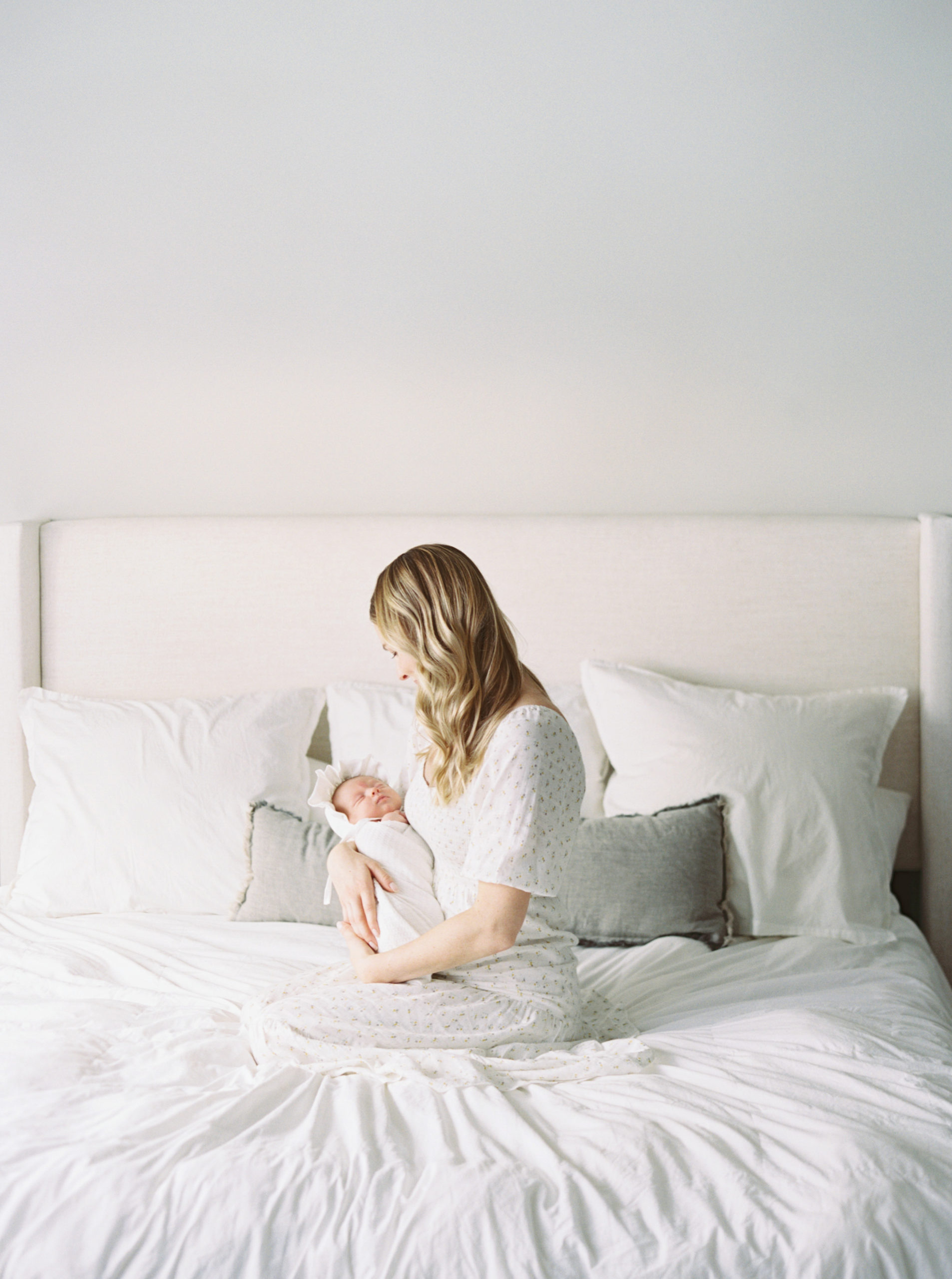 Mother cuddling baby in a beautiful, bright, Milwaukee bedroom