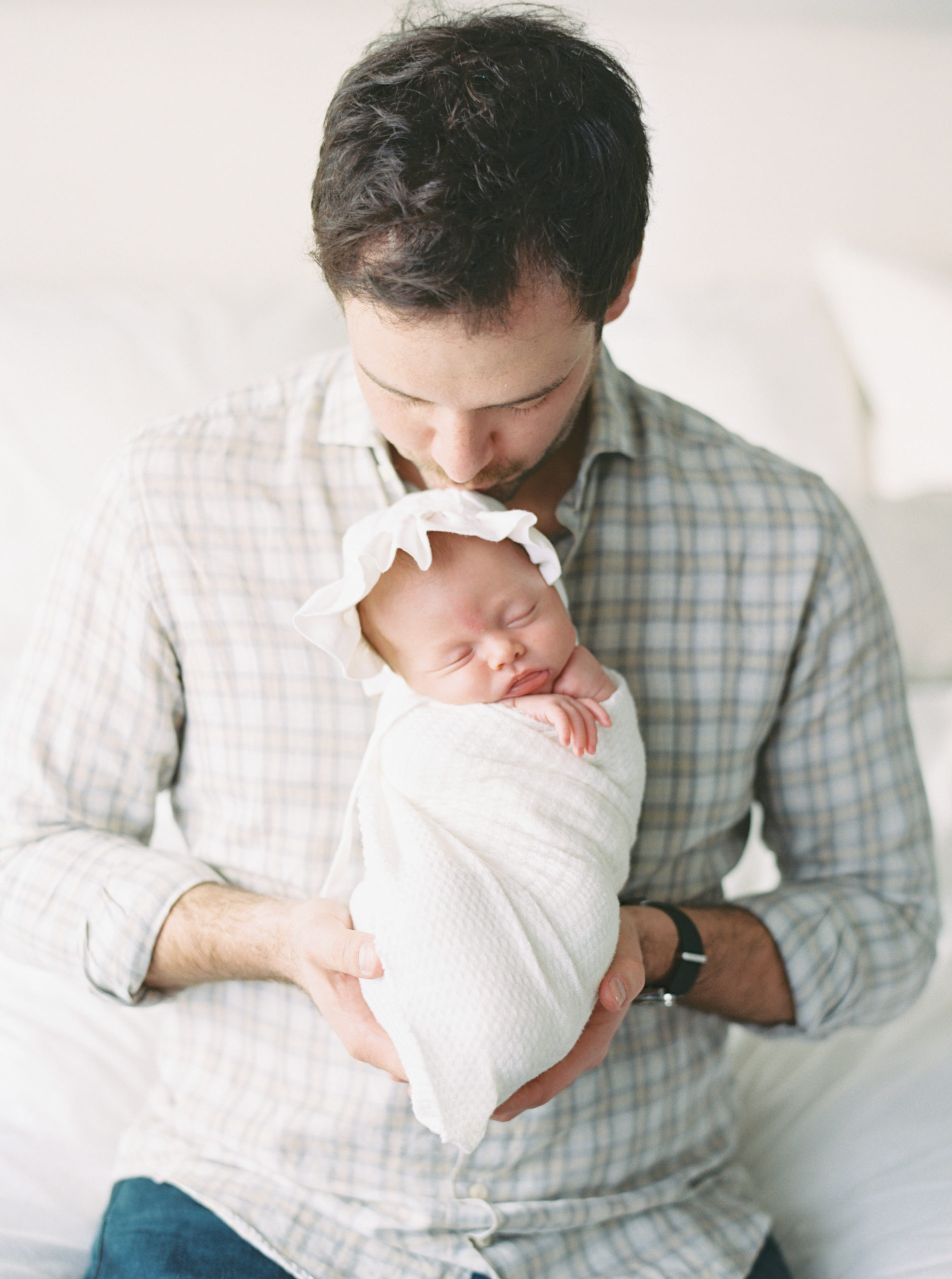 Father cuddling baby in a beautiful, bright, Milwaukee bedroom
