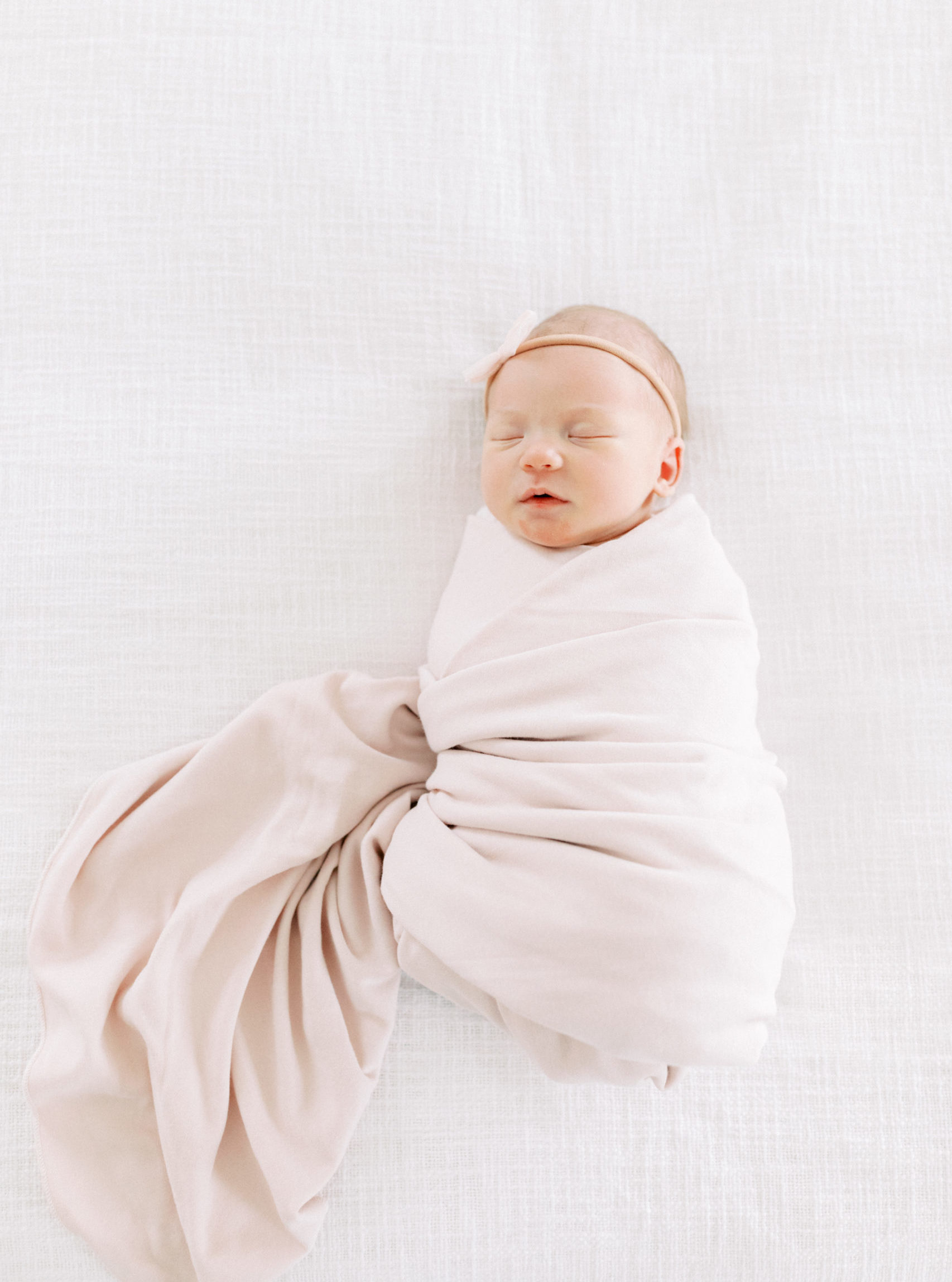 newborn baby on bed during photo session with photographer in milwaukee talia laird photography