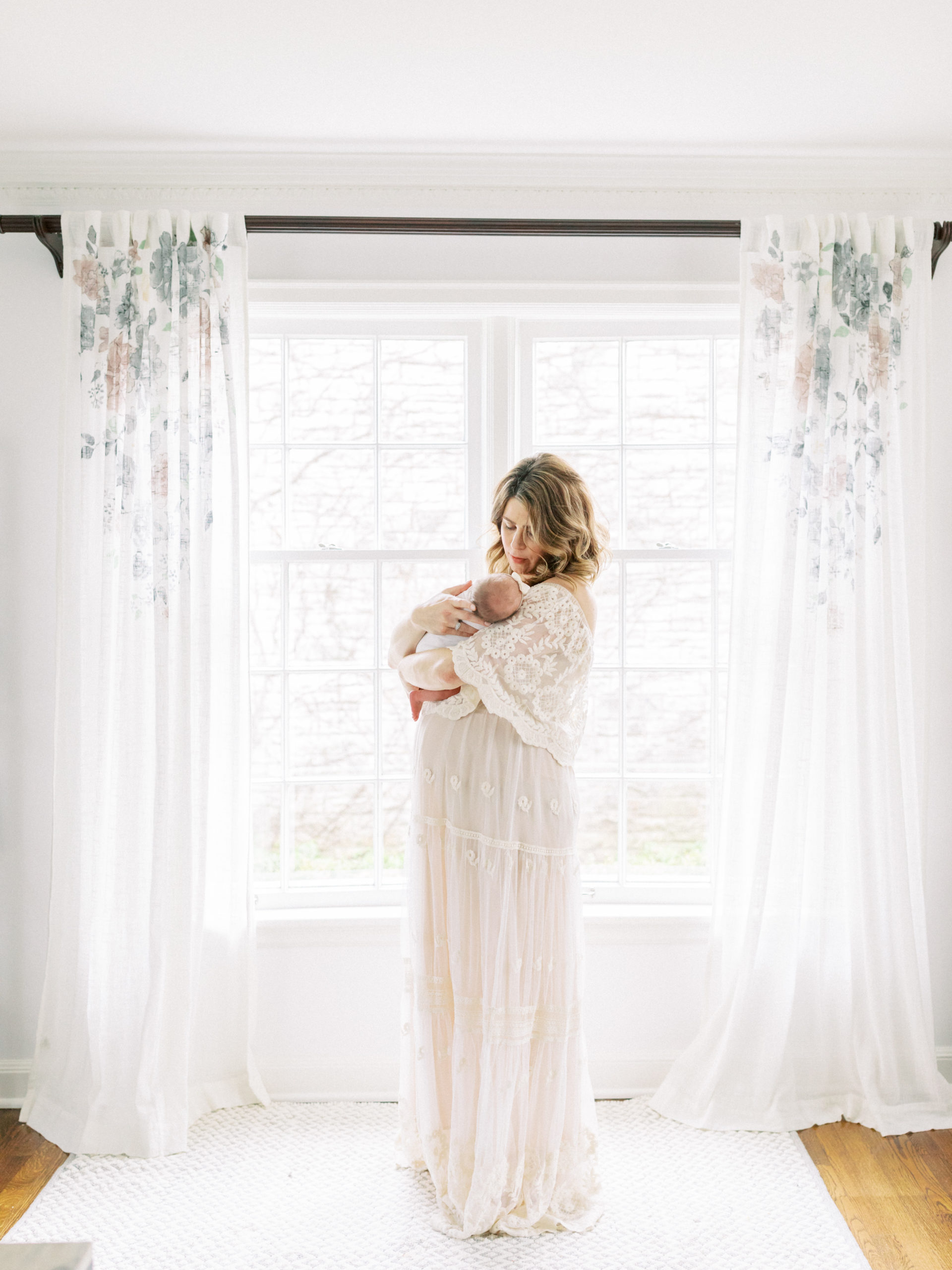 mother holding newborn baby during photo session with photographer in milwaukee talia laird photography