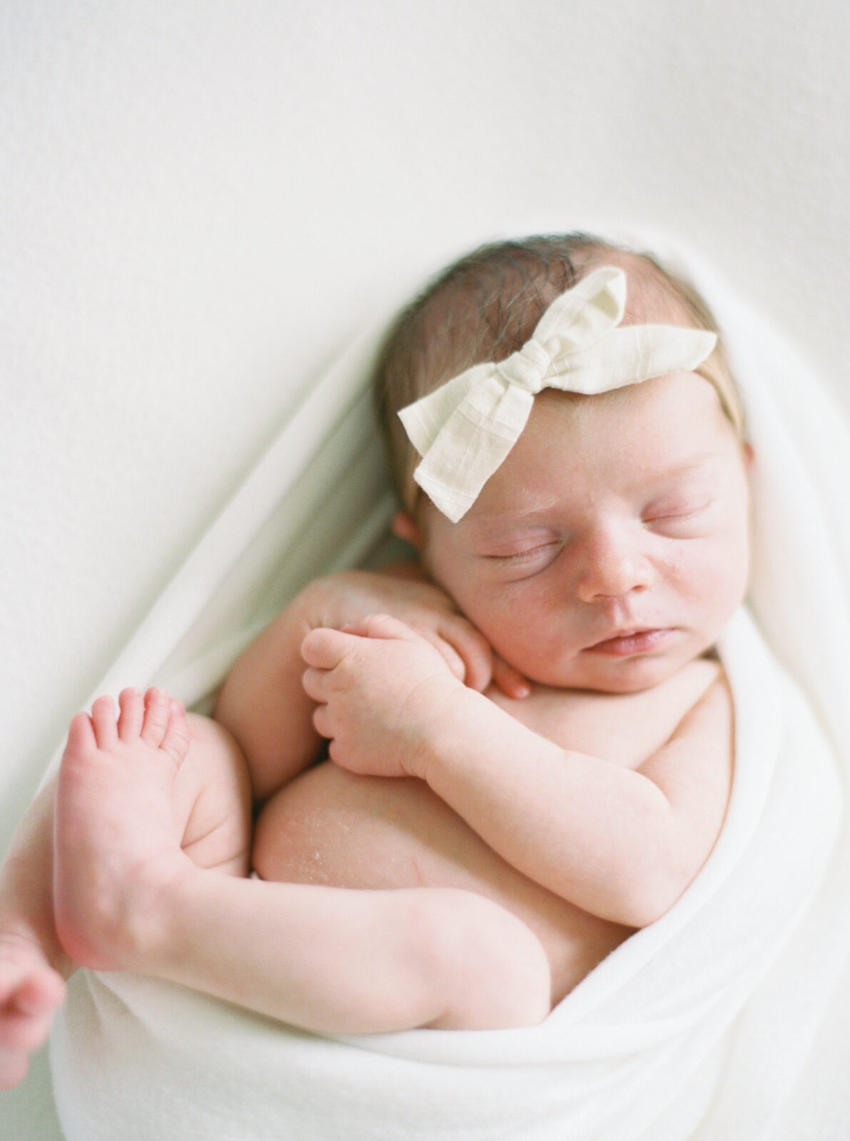 sleeping newborn in an all white studio in Milwaukee, photographed by Milwaukee studio photographer Talia Laird Photography