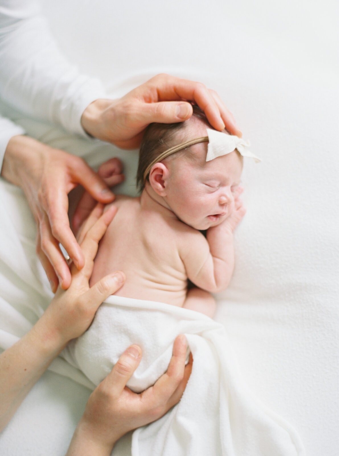 newborn baby girl in an all white studio in milwaukee studio newborn session with Talia Laird Photography