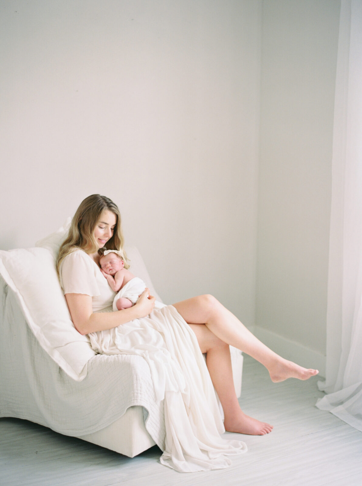 mom snuggling baby in milwaukee natural light studio newborn session with Talia Laird Photography